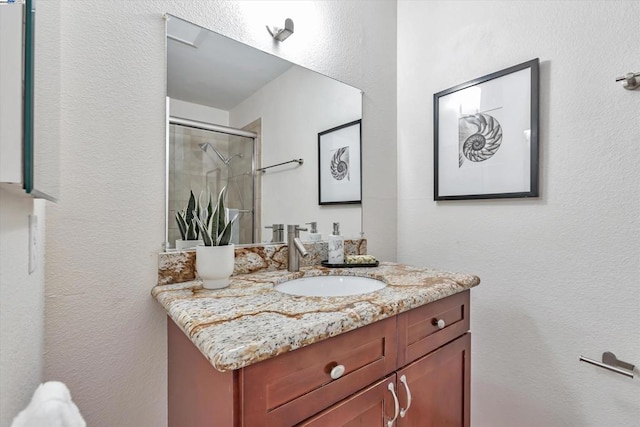 bathroom featuring vanity and an enclosed shower