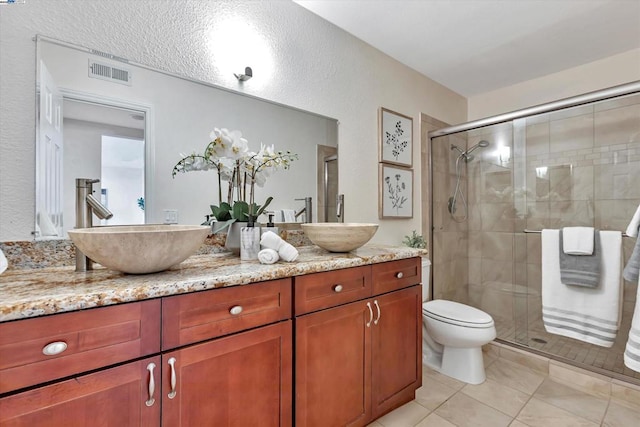 bathroom with tile patterned flooring, vanity, toilet, a shower with door, and a textured ceiling