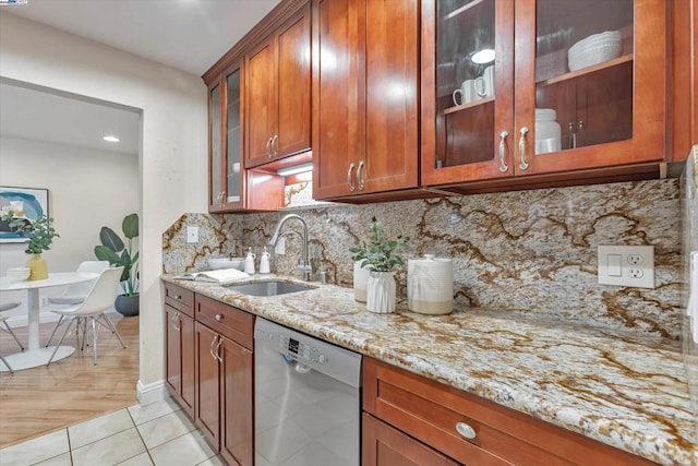 kitchen featuring sink, light tile patterned floors, light stone counters, tasteful backsplash, and stainless steel dishwasher