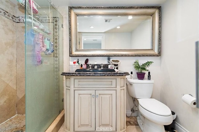 bathroom with vanity, toilet, and a shower with door