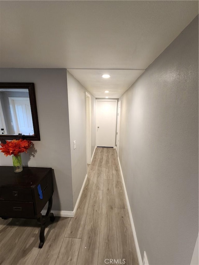 corridor with light hardwood / wood-style floors