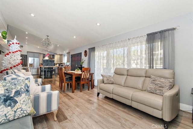 living room featuring lofted ceiling and light hardwood / wood-style floors