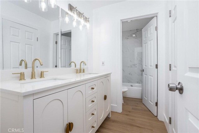 full bathroom featuring toilet, tiled shower / bath, hardwood / wood-style flooring, and vanity