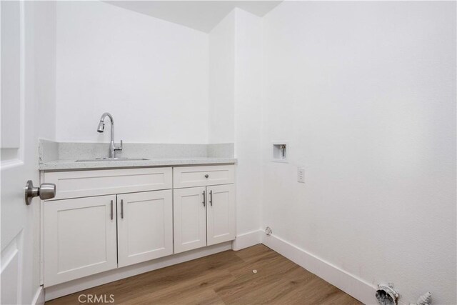 washroom with hookup for a gas dryer, wood-type flooring, sink, washer hookup, and cabinets