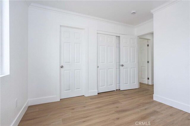 unfurnished bedroom featuring ornamental molding and light hardwood / wood-style floors