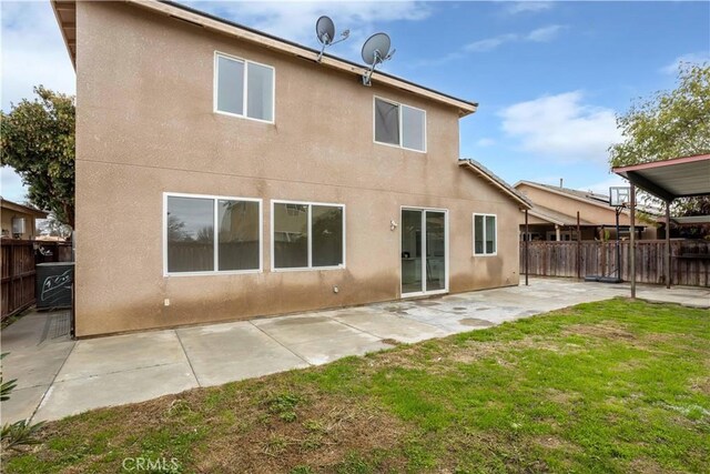 rear view of house with a lawn and a patio