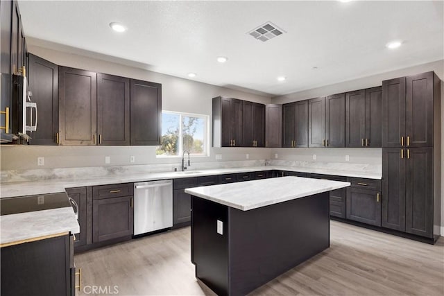 kitchen featuring dark brown cabinetry, sink, a center island, light hardwood / wood-style flooring, and stainless steel dishwasher