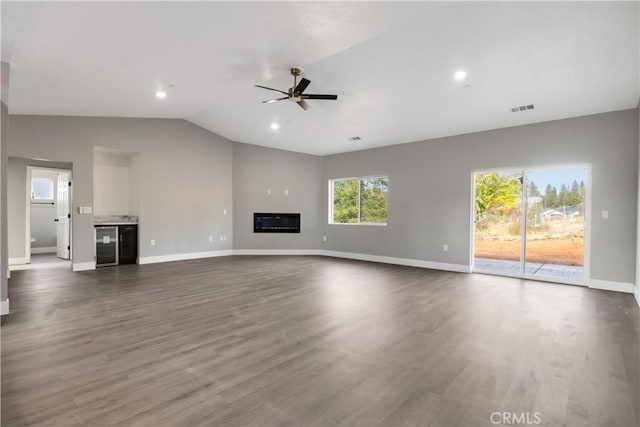 unfurnished living room with ceiling fan, lofted ceiling, wine cooler, and dark hardwood / wood-style flooring