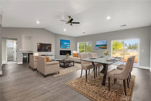 dining area featuring wood-type flooring, lofted ceiling, wine cooler, and ceiling fan