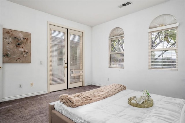 bedroom featuring french doors, dark carpet, access to outside, and multiple windows