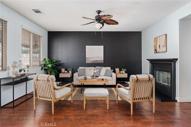 living room featuring ceiling fan and dark wood-type flooring