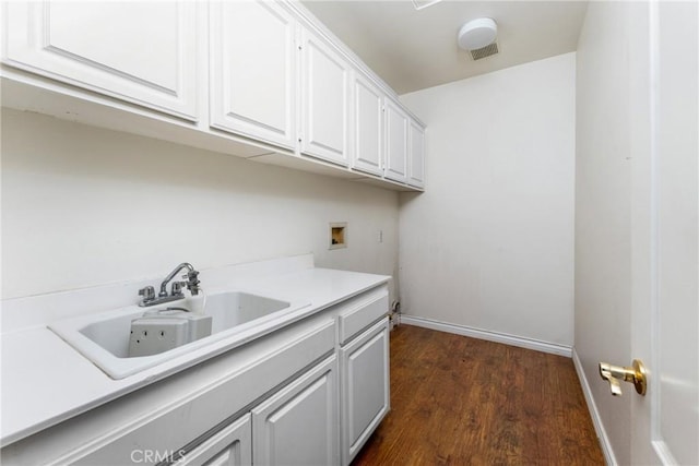 clothes washing area with washer hookup, cabinets, sink, and dark wood-type flooring