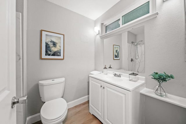 bathroom with walk in shower, hardwood / wood-style flooring, vanity, and toilet