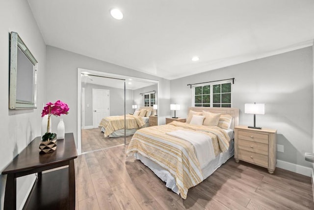 bedroom featuring a closet, hardwood / wood-style floors, and vaulted ceiling