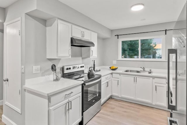 kitchen with sink, light wood-type flooring, stainless steel electric range, and white cabinetry