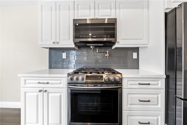 kitchen featuring white cabinets, backsplash, and appliances with stainless steel finishes