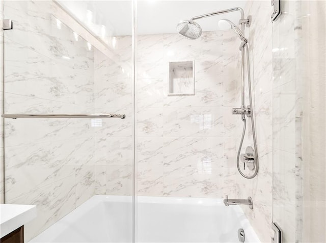 bathroom featuring tiled shower / bath combo and vanity