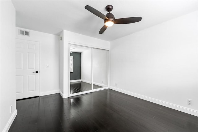 unfurnished bedroom with ceiling fan, a closet, and dark hardwood / wood-style flooring