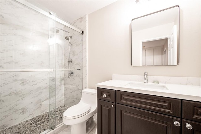 bathroom featuring a shower with door, toilet, and vanity