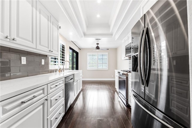 kitchen featuring tasteful backsplash, ceiling fan, white cabinetry, appliances with stainless steel finishes, and light stone countertops