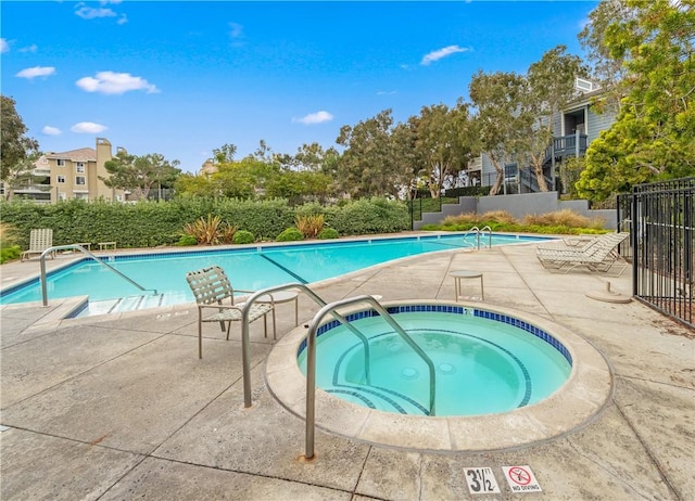 view of swimming pool featuring a community hot tub and a patio