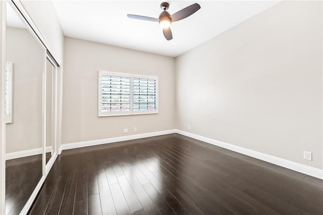 unfurnished bedroom with dark wood-type flooring, ceiling fan, and a closet