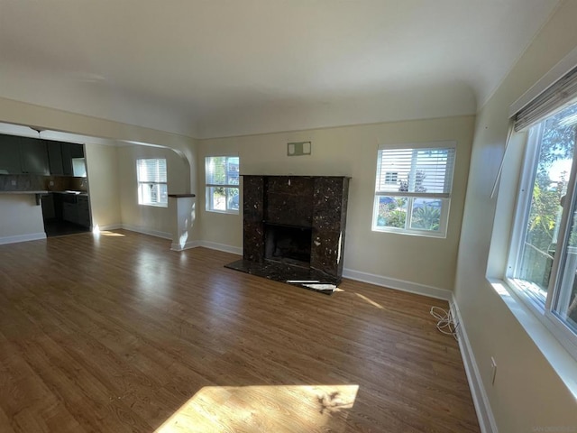 unfurnished living room with dark wood-type flooring and a fireplace