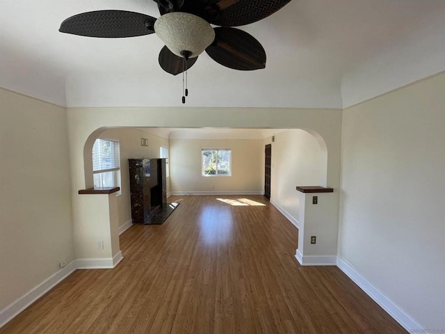 unfurnished living room with dark wood-type flooring and ceiling fan