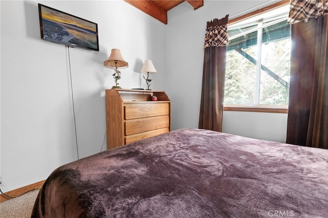 bedroom featuring carpet floors and beamed ceiling