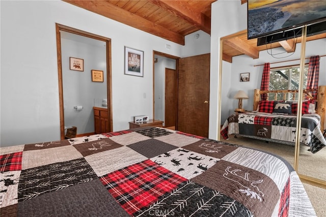 carpeted bedroom with a closet, beamed ceiling, and wooden ceiling