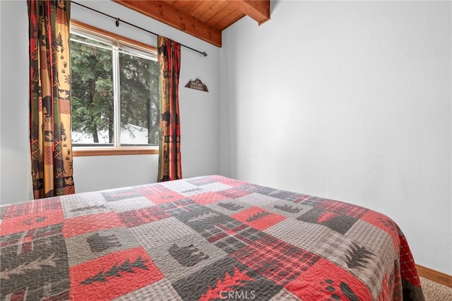 bedroom with carpet flooring, wood ceiling, and vaulted ceiling with beams