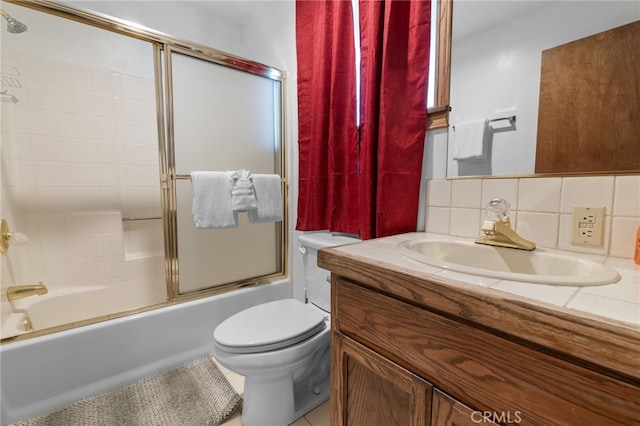 full bathroom featuring toilet, decorative backsplash, enclosed tub / shower combo, and vanity