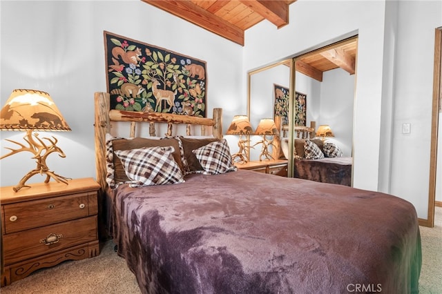 carpeted bedroom featuring wooden ceiling, a closet, and lofted ceiling with beams