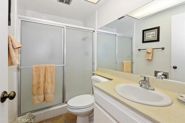 bathroom with a shower with shower door, tile patterned floors, toilet, and vanity