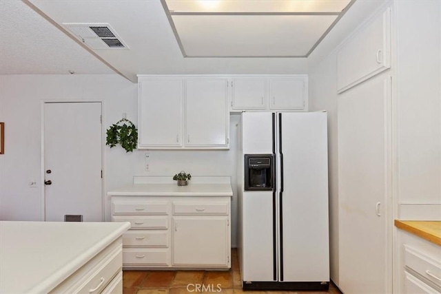 kitchen with white refrigerator with ice dispenser and white cabinetry