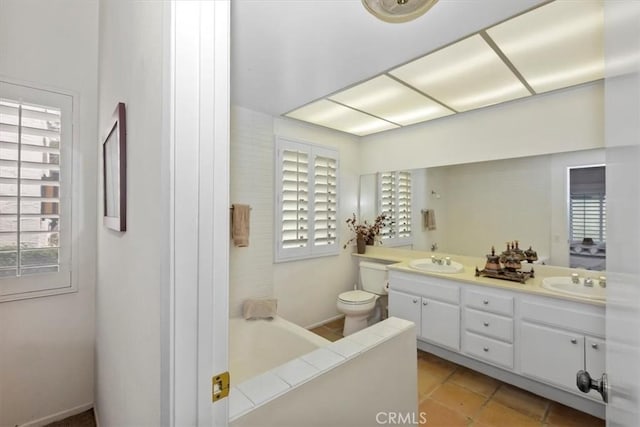 bathroom featuring tile patterned flooring, vanity, a bathtub, and toilet