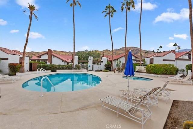 view of swimming pool with a mountain view and a patio area