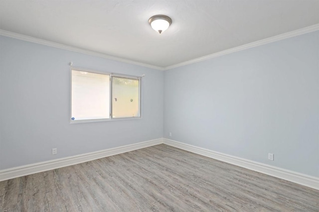 spare room featuring hardwood / wood-style flooring and ornamental molding