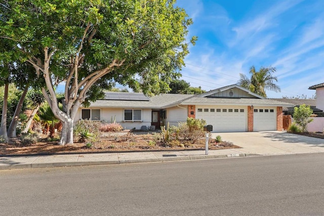 ranch-style house featuring solar panels and a garage