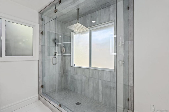 bathroom with a shower with shower door and tile patterned floors