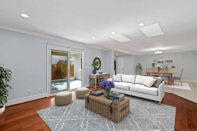 living room with a skylight, crown molding, and hardwood / wood-style floors