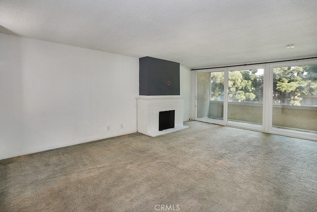 6405 Green Valley Cir Unit 209, Culver City, CA 90230 - unfurnished living room featuring a textured ceiling, carpet flooring, and a fireplace