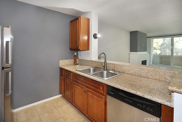6405 Green Valley Cir Unit 209, Culver City, CA 90230 - kitchen featuring a sink, stainless steel appliances, light tile patterned flooring, baseboards, and a textured ceiling