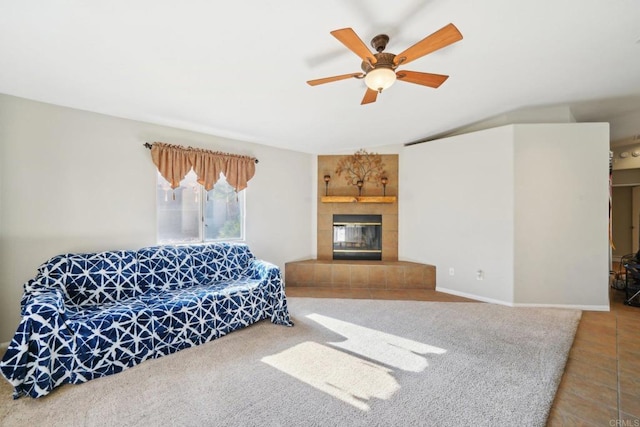 carpeted living room with ceiling fan and a tiled fireplace