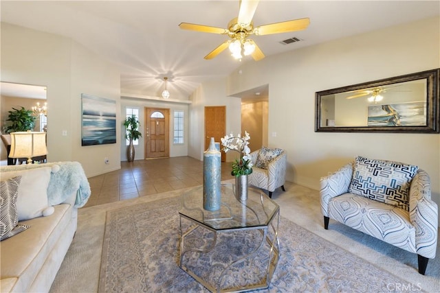 living room featuring ceiling fan with notable chandelier and light tile patterned flooring