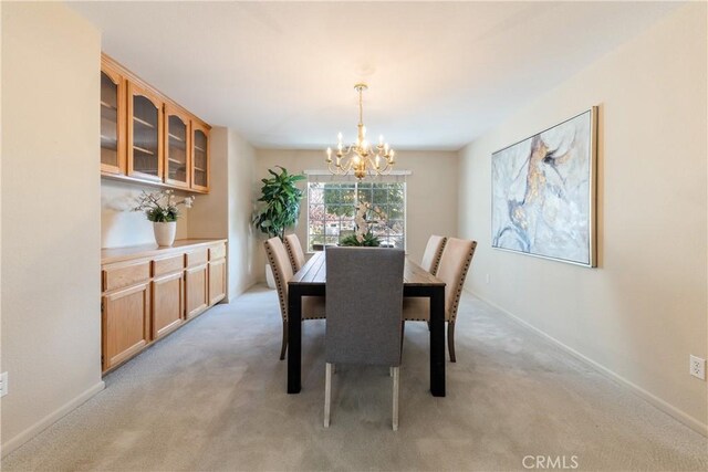 carpeted dining area with a chandelier