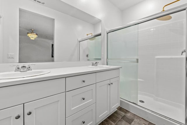 bathroom with a shower with shower door and vanity