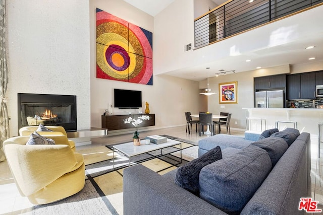 living room featuring a towering ceiling and a large fireplace