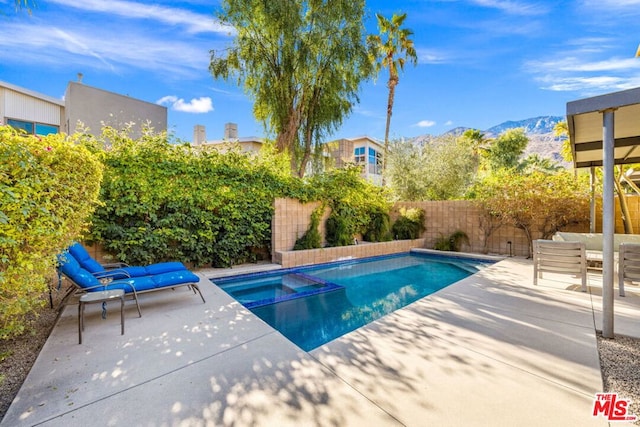 view of swimming pool with a mountain view, a patio, and an in ground hot tub