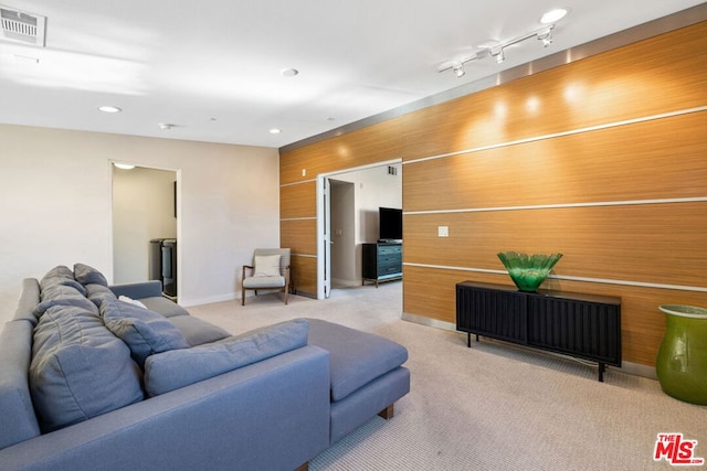 living room with light carpet and wood walls